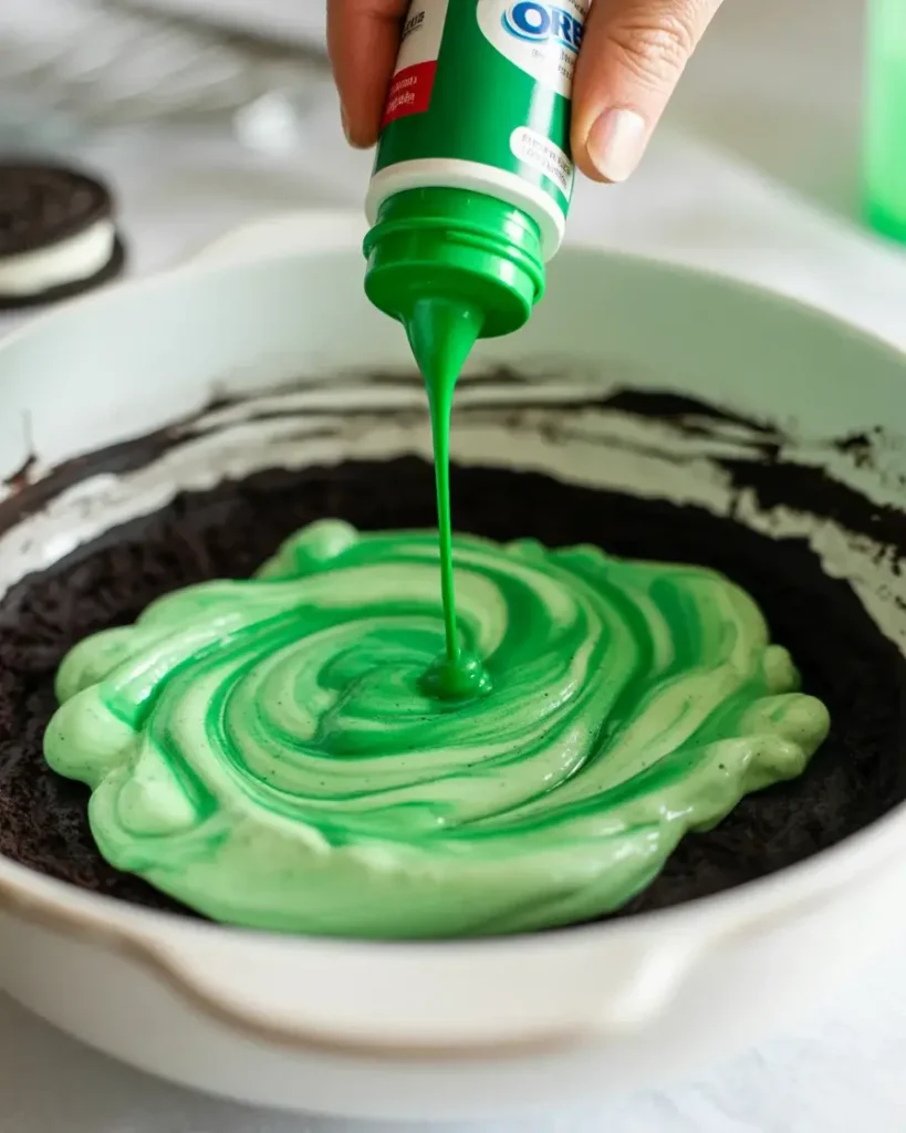 Adding green gel food coloring to create that iconic Grinch-green shade
