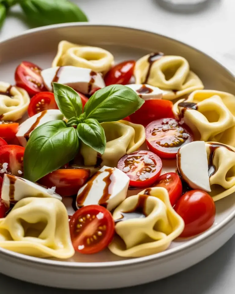 Fresh tortellini caprese salad with cherry tomatoes, mozzarella, basil, and balsamic glaze